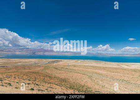 The sacred Manasarovar lake with blue transparent water in the mountains of Tibet under cloudy sky. Ngari scenery in West Tibet. Sacred place for Budd Stock Photo