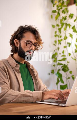 Cheerful male writer working on a novel on his laptop at home. Stock Photo