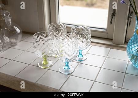 Stylish handmade empty fine wine glasses on the table by the window. High quality photo Stock Photo