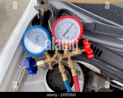 Mechanic Using A/C Manifold Gauge Set to Check Air Condition System Stock Photo