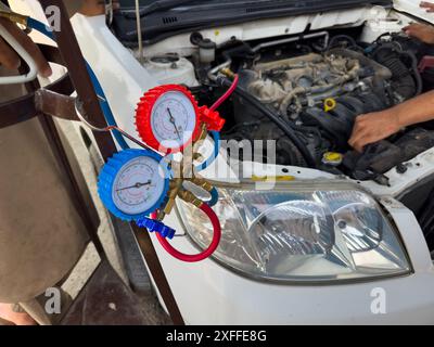 Mechanic Checking Automotive AC Pressure Gauges with Tools Stock Photo