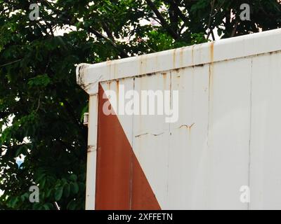 Corroded metal background. The metal wall is painted white with rust spots. Rusted metal background with rust marks, rust stains. Rystycorrosion. Stock Photo