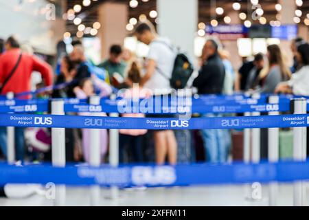 Duesseldorf, Germany. 03rd July, 2024. Passengers queue at the airport in front of the check-in counter. Credit: Christoph Reichwein/dpa/Alamy Live News Stock Photo