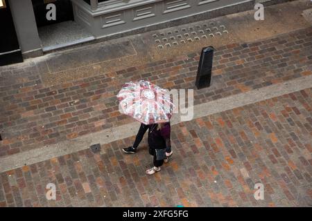 Pedestrians sheltering under their umbrella walk in London Stock Photo ...