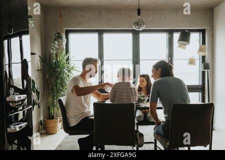 Family having lunch on dining table while sitting in living room at home Stock Photo