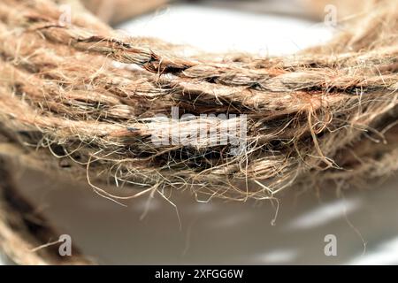 On a white background lies a skein of rope made from flax fibers. Stock Photo