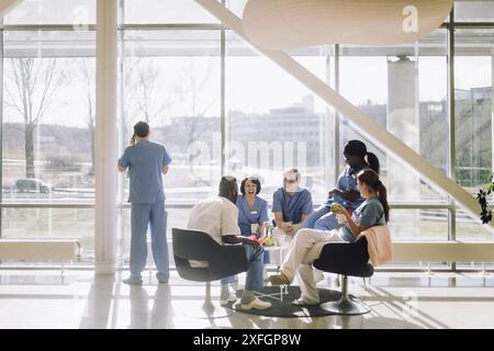 Team of male and female medical professionals having fun during coffee break at hospital cafeteria Stock Photo