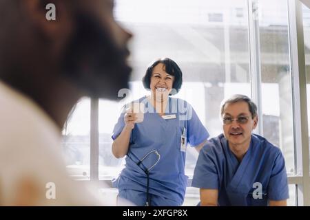 Smiling male and female senior doctors during coffee break at hospital Stock Photo