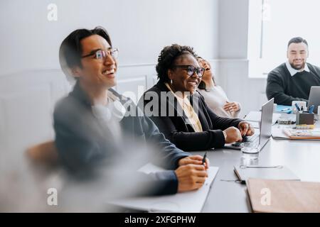 Happy male and female business professionals sitting in meeting at office Stock Photo