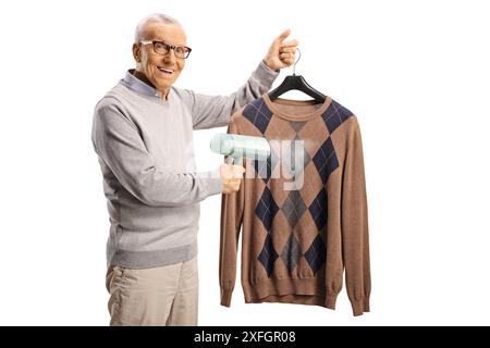 Elderly man using a hand steam iron and smiling isolated on white background Stock Photo