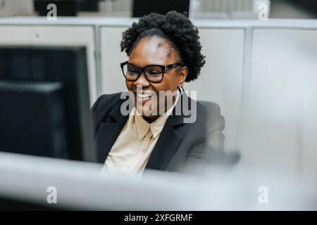 Smiling businesswoman wearing eyeglasses working in office Stock Photo