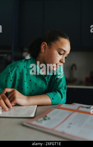Focused girl reading while sitting at home Stock Photo