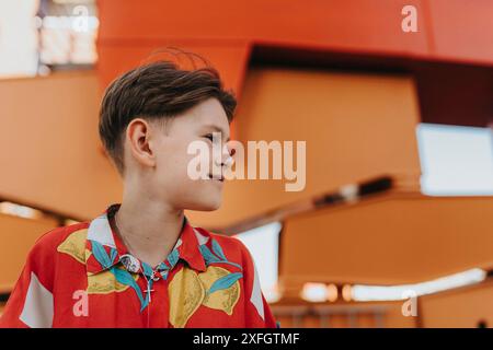 Smiling boy looking away against metal structure Stock Photo