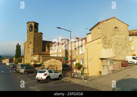 Langeac, France - May 27, 2023: A picturesque street scene in Langeac, France, showcasing a historic church tower and stone buildings bathed in the so Stock Photo