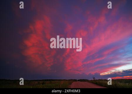 Mammatus clouds in the morning sky with red sunrise light after storm Stock Photo