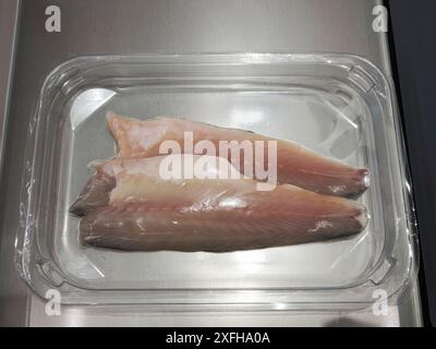 Raw sea bass fillets in vacuum pack for sous vide cooking on stainless steel top Stock Photo