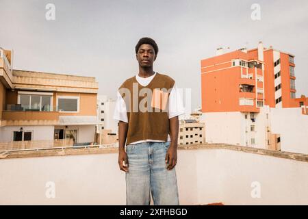Portrait of young man in casuals standing on rooftop Stock Photo