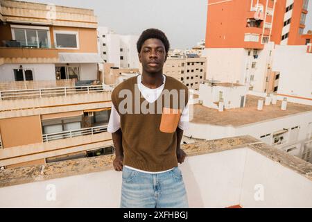 Portrait of confident young man leaning on terrace wall Stock Photo