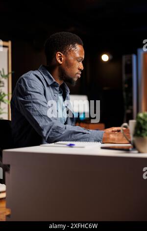 Ambitious pupil acquires knowledge in business administration via web based training program, focusing on webinar with certified mentor. Young man decided to study banking and commerce. Stock Photo