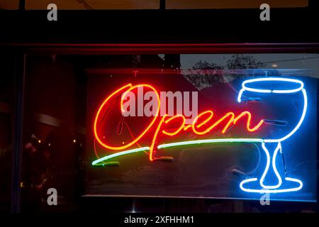 Neon sign announcing open business in storefront window Stock Photo