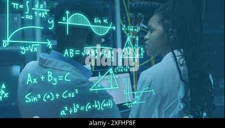 Image of mathematical equations, diagrams, african american engineers discussing in server room Stock Photo