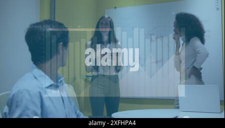 Image of multiple graphs, loading bar, diverse man working on laptop and talking with coworkers Stock Photo