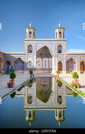 Awesome view of the Nasir al-Mulk Mosque (Pink Mosque) reflected in pool in the middle of traditional courtyard in Shiraz, Iran. Stock Photo