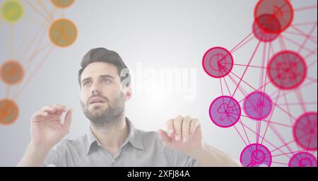 Digital composite image of two globe of digital icons spinning over man gesturing against grey backg Stock Photo