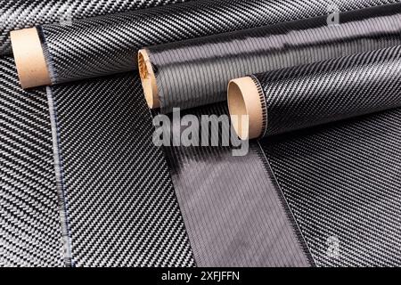 Rolls with various real woven carbon fiber enforcement raw material cloth. composite material automotive and car tuning  industry and high tech backgr Stock Photo