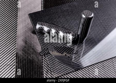 lightweight carbon fiber tuning parts and CFK sheet on composite  raw material cloth.  automotive and car racing  industry and high tech background. Stock Photo