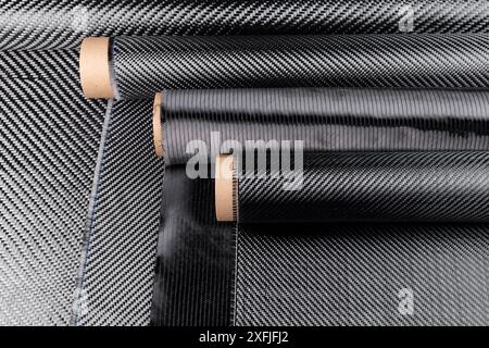 Rolls with various real woven carbon fiber enforcement raw material cloth. composite material industry and high tech background. Stock Photo