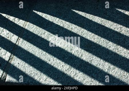 Abstract minimal background of contrasting shadow lines on a cement floor top view. Patterns and textures. Light and shadows pattern. Urban street. Stock Photo