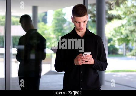 Smiling young indian business man professional, eastern businessman executive standing outdoors on street reading ebook holding using digital tablet online technology in night city. Guy tablet Stock Photo