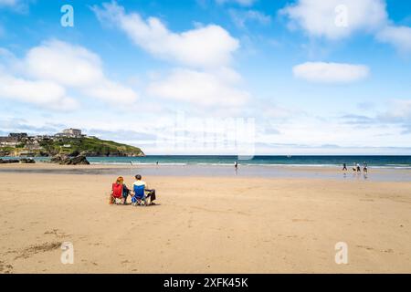 Holidaymakers sitting in chairs on Great Western Gt Western beach at low tide in Newquay in Cornwall in the UK. Stock Photo