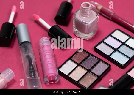 Various decorative cosmetics and brushes on a pink background. Stock Photo