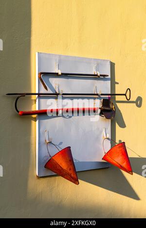 old fire shield on the wall of a building. Fire shields are part of the fire equipment and the primary means of fire extinguishing Stock Photo