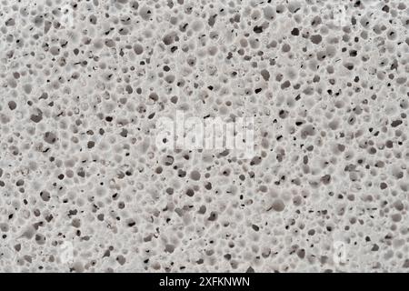 Close-up view of white marble countertop with textured surface made up of small, irregularly shaped pits and bumps. Stock Photo