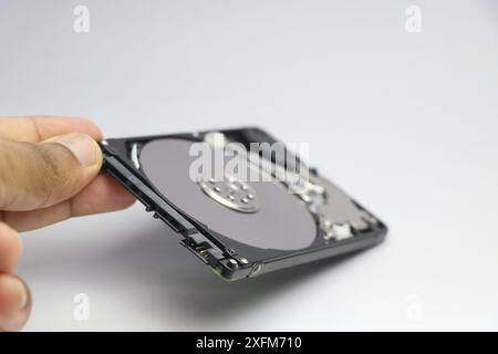 Computer hard disk drive with its top case removed to have a look at the internal components. Repairing old hard disks Stock Photo