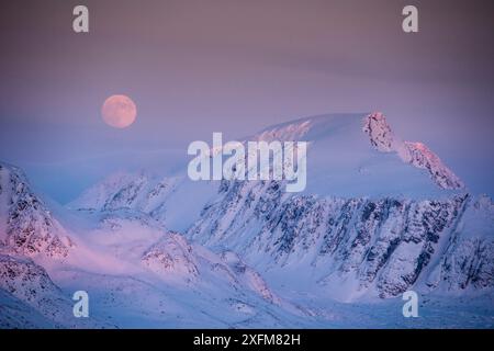 Full moon above Svalbard mountains in Smeerenburgfjorden, Spitsbergen, Svalbard, Norway, March. Stock Photo