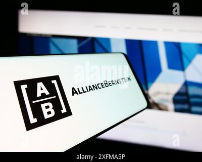 Smartphone with logo of US investment company AllianceBernstein Holding L.P. (AB) in front of website. Focus on center-left of phone display. Stock Photo