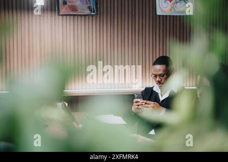 Professional businessman texting on smart phone in a modern office setting Stock Photo