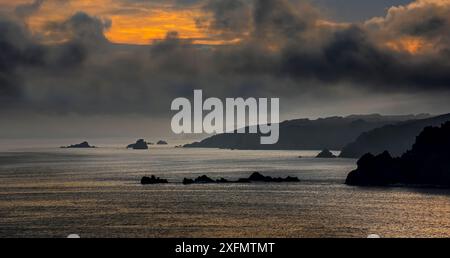 Silhouette of cliffs at the Pointe de Penharn at sunrise with storm clouds, Cléden-Cap-Sizun, Finistère, Brittany, France, September 2015. Stock Photo