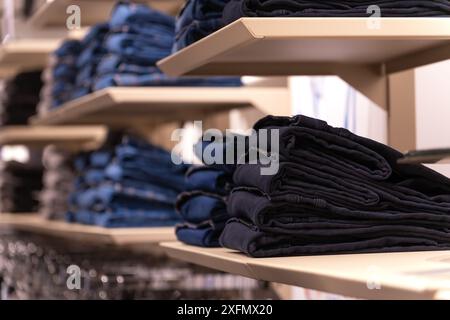 Colorful jeans in the store. Background theme of the trade sale. Clothes on a hanger in the store Stock Photo