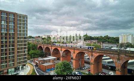 Stockport viaduct with a Northern local commuter train passing over Stock Photo