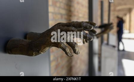 Visitors view the exhibition Let's Not Forget the Crimes of Communism in Velehrad, Czech Republic, where start the two-day Day of Good Will People on July 4, 2024. The depiction of hands behind bars points to 33 priests who were innocently convicted and imprisoned by the communist regime. The aim of the exhibition is to recall the events surrounding the publication of the Pastoral Letter in 1949. This year marks the 75th anniversary of the publication of the pastoral letter 'The Voice of the Czechoslovak Bishops and Ordinaries to the Faithful in the Hour of Great Trial', which was adopted by t Stock Photo