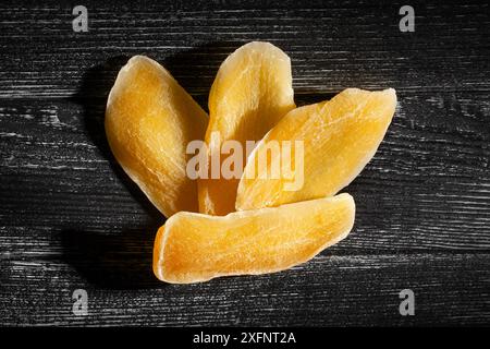dried mango on black wood background top view Stock Photo
