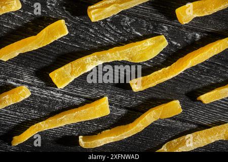 dried cantaloupe sticks on black wood background top view Stock Photo