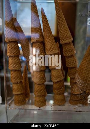 A pile of waffle cones for ice cream ready to be filled with ice cream in a cafe, restaurant. Showcase of a cafe, a pastry shop, a restaurant Stock Photo