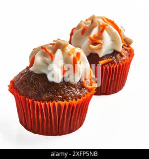 Two cupcakes with creamy frosting and orange sprinkles isolated on a white background. Stock Photo