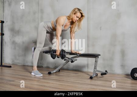 Middle-aged woman athlete working out with dumbbells in the gym Stock Photo
